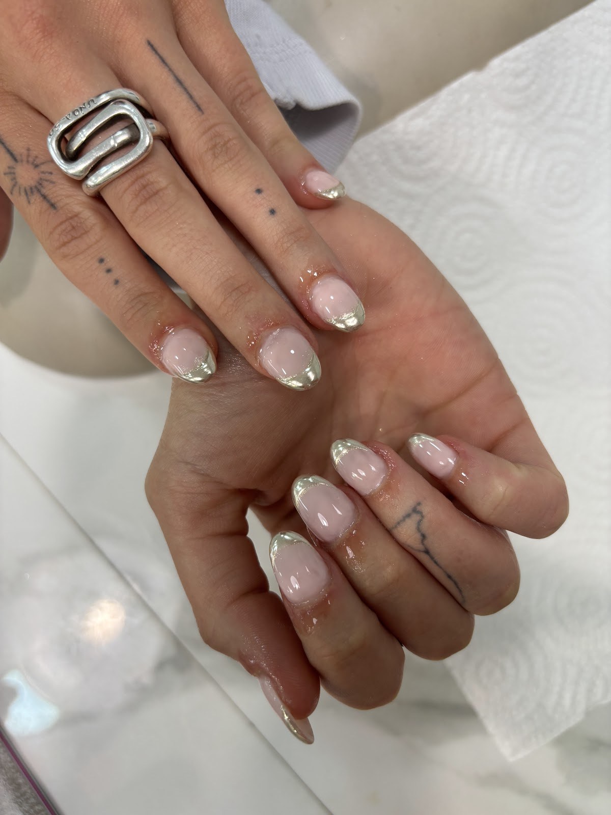 French fine à effet chrome sur ongles naturels courts.